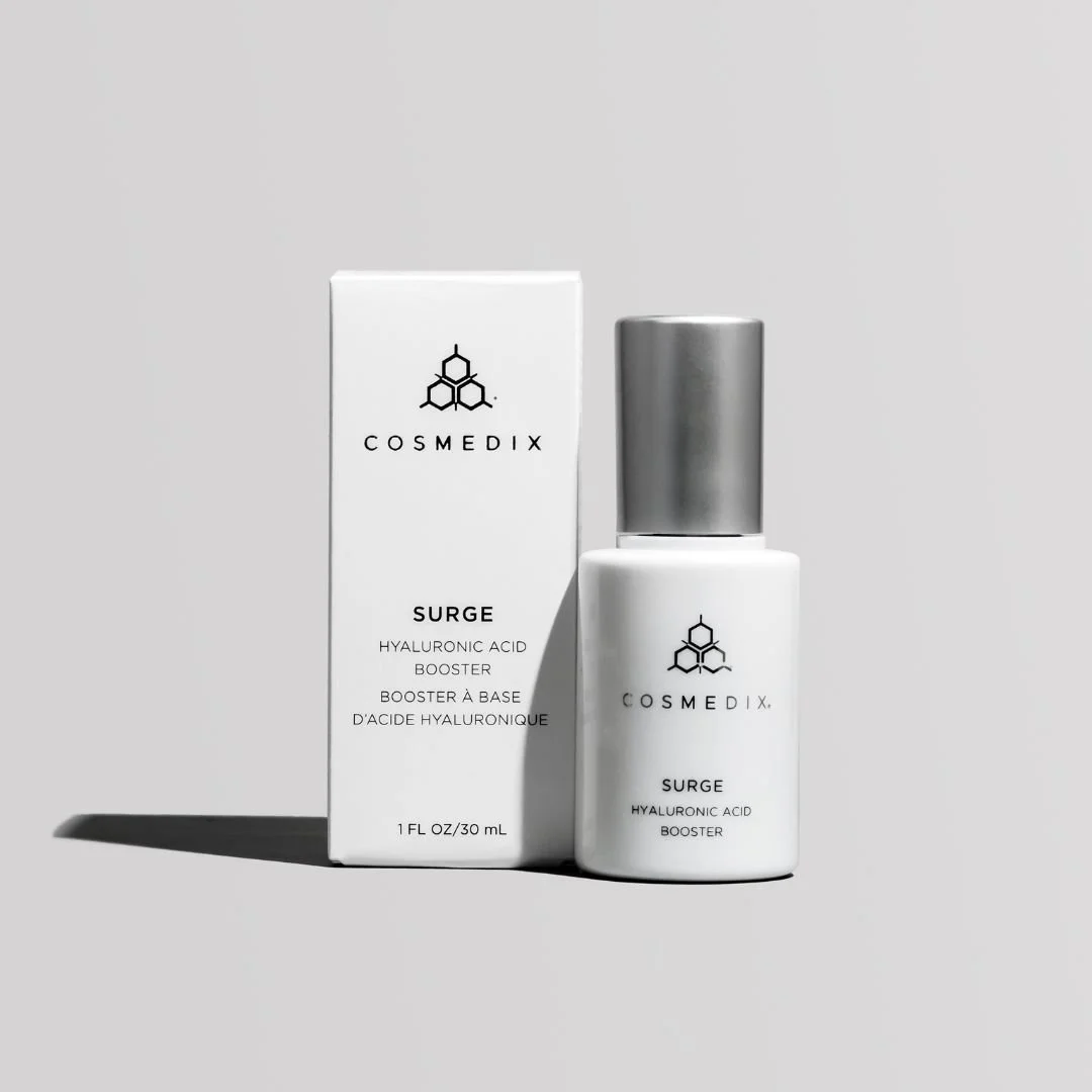 COSMEDIX Surge Hyaluronic Acid Booster bottle beside its 30 mL carton on a light gray background.