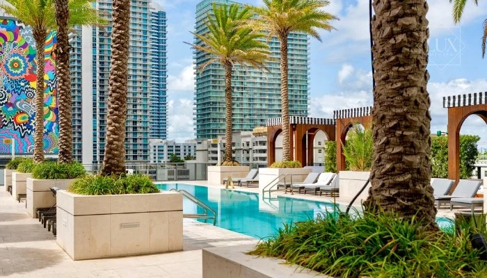 Rooftop pool deck at SLS LUX Brickell, home to Lux MedSpa Brickell, with palm trees and Miami skyline views