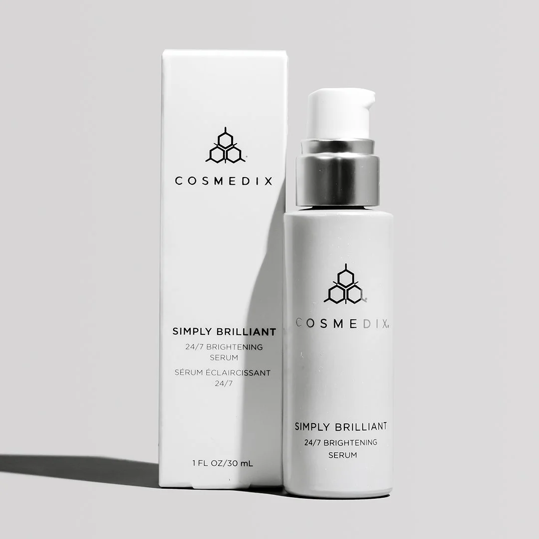COSMEDIX Simply Brilliant 24/7 Brightening Serum pump bottle beside its box on a light gray background.