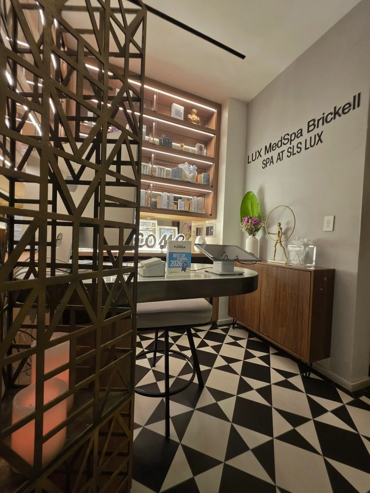 Reception at LUX MedSpa Brickell, with spa signage and a Best of Florida 2026 award plaque.