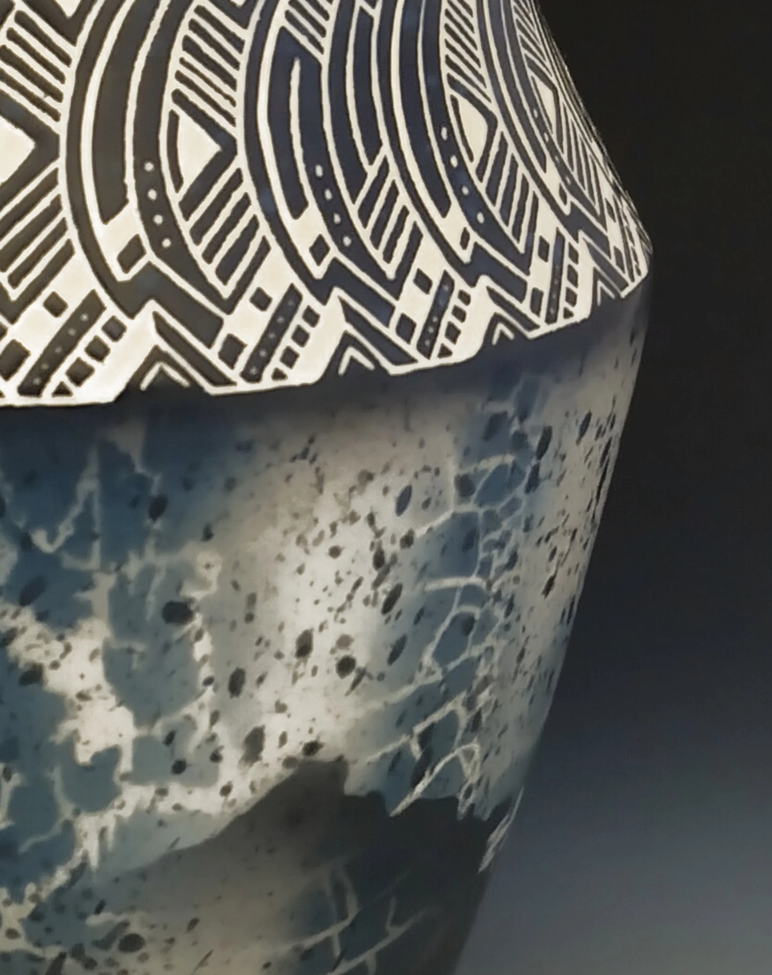 Close-up of a decorative item with black and white geometric patterns on a textured surface.