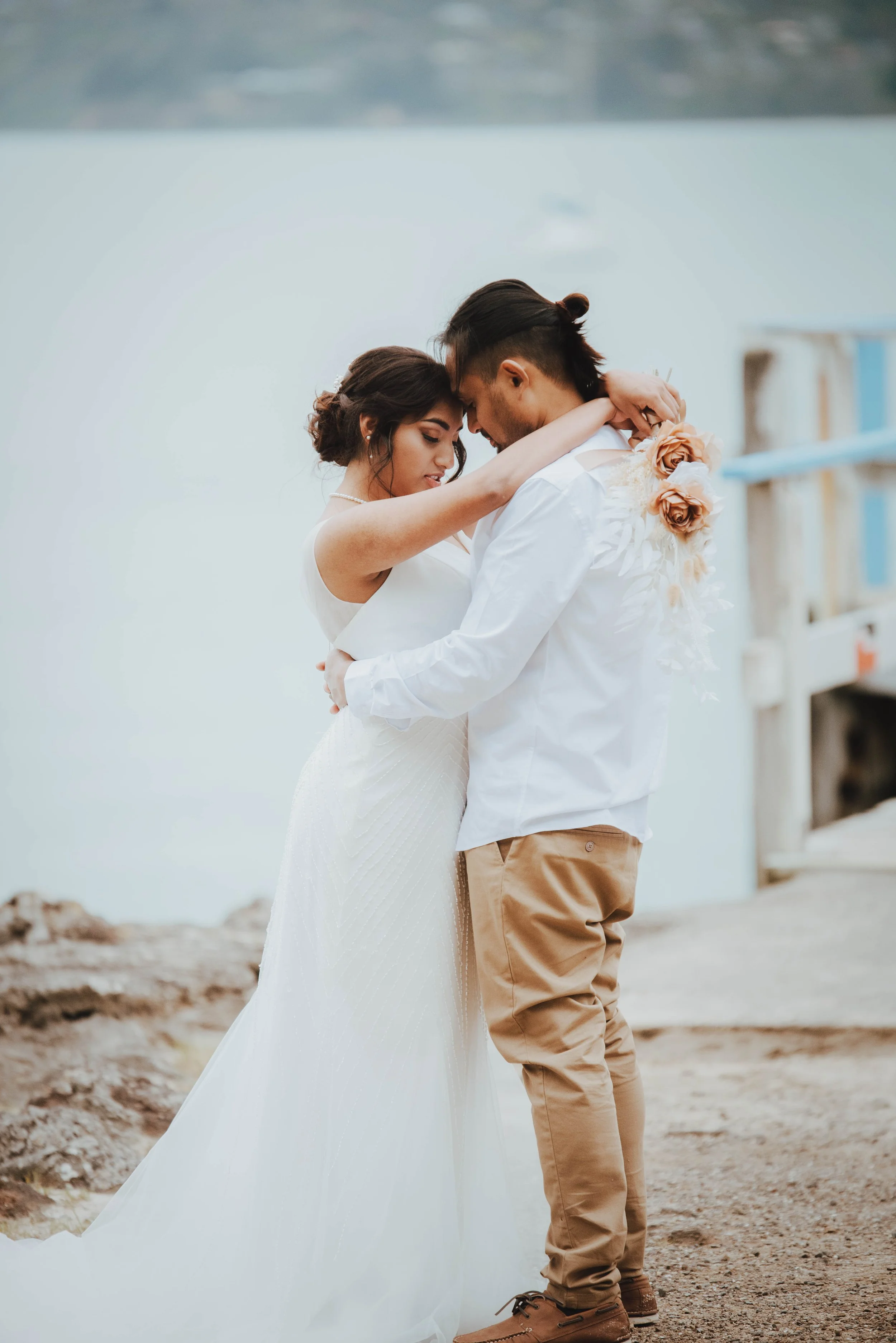 newlyweds hugging at beach portraits newlyweds hugging at beach portraits