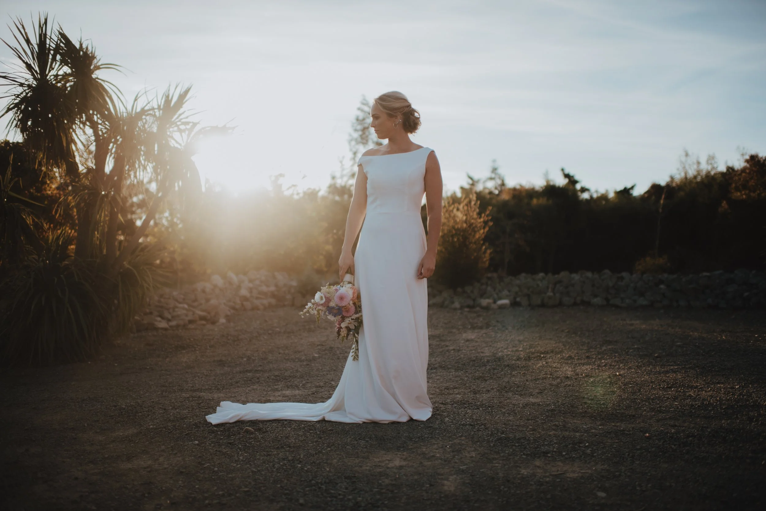 golden hour portrait of bride with bouquet in rural setting
