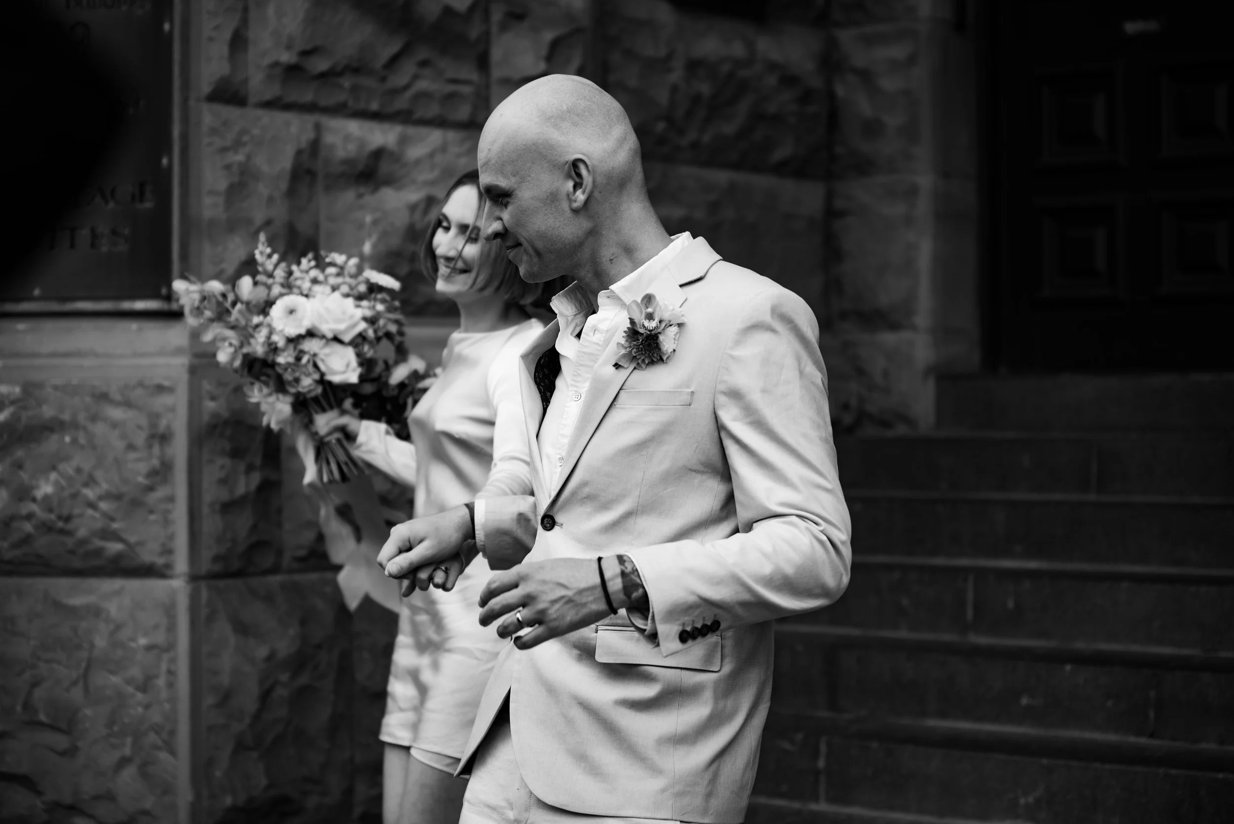 timeless black and white portrait of couple running down stairs of OGB in christchurch timeless black and white portrait of couple running down stairs of OGB in christchurch