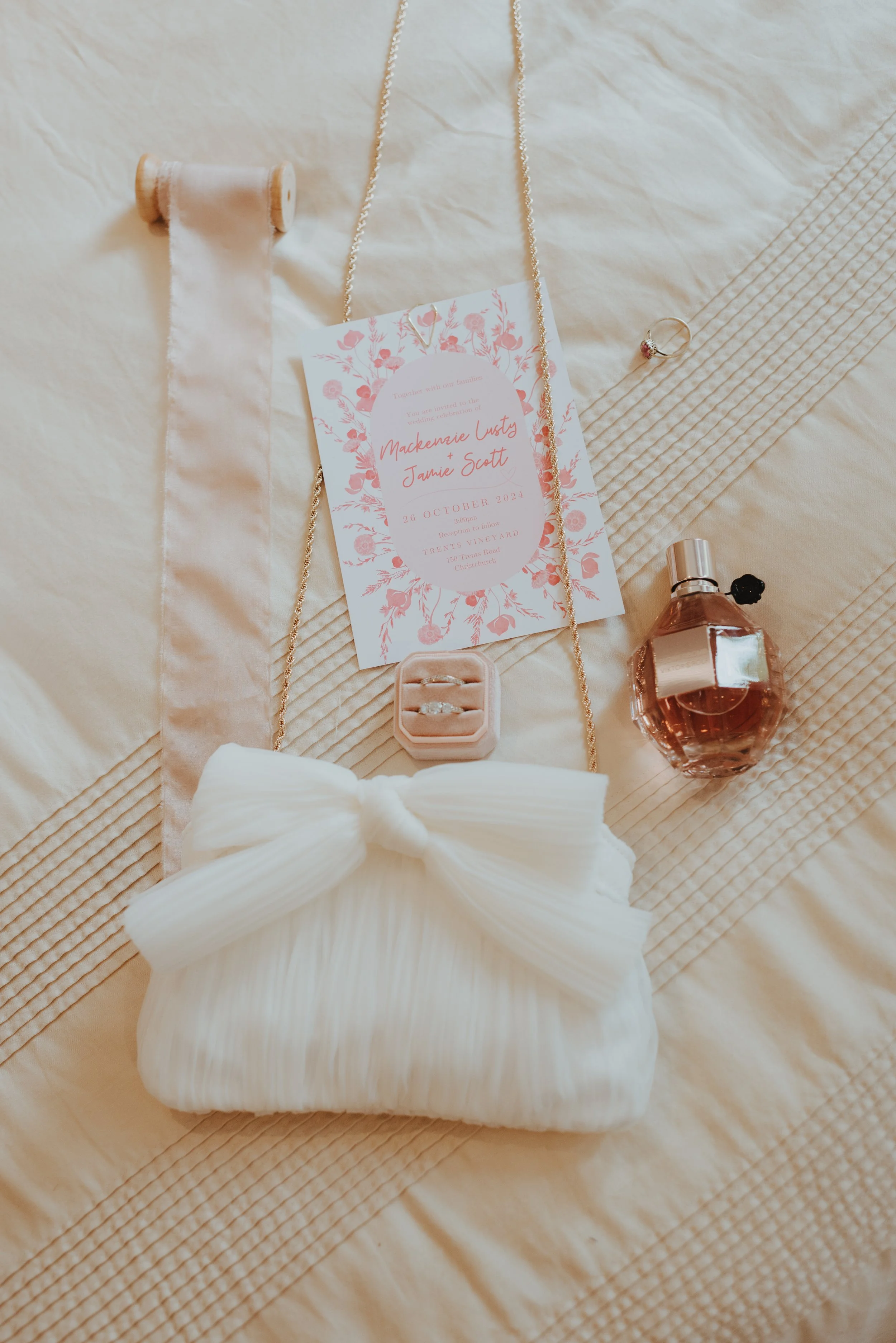 pink flatlay including fabric perfume rings invitation and white tulle bag pink flatlay including fabric perfume rings invitation and white tulle bag