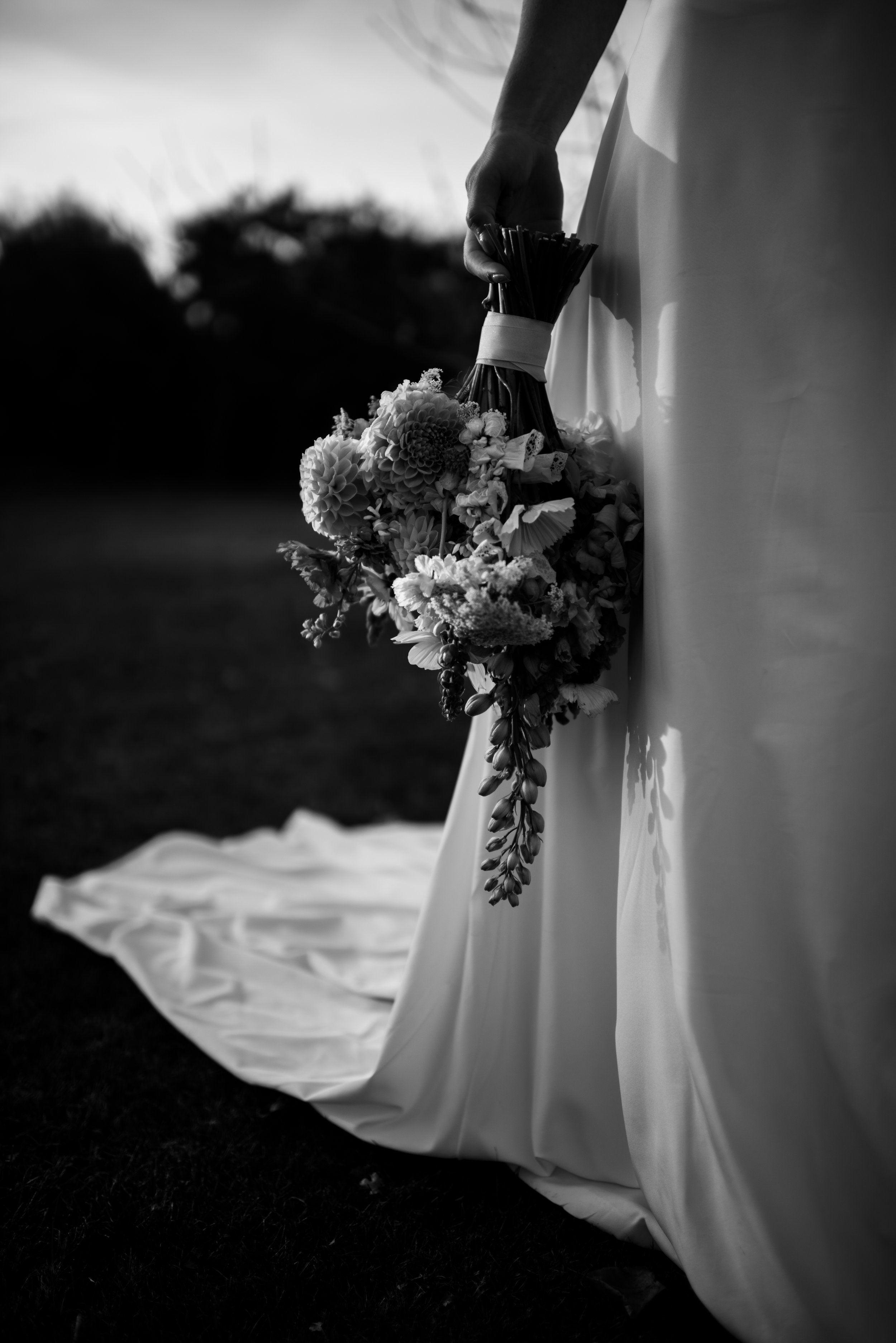 black and white timeless classic detail of dress train and bridal bouquet