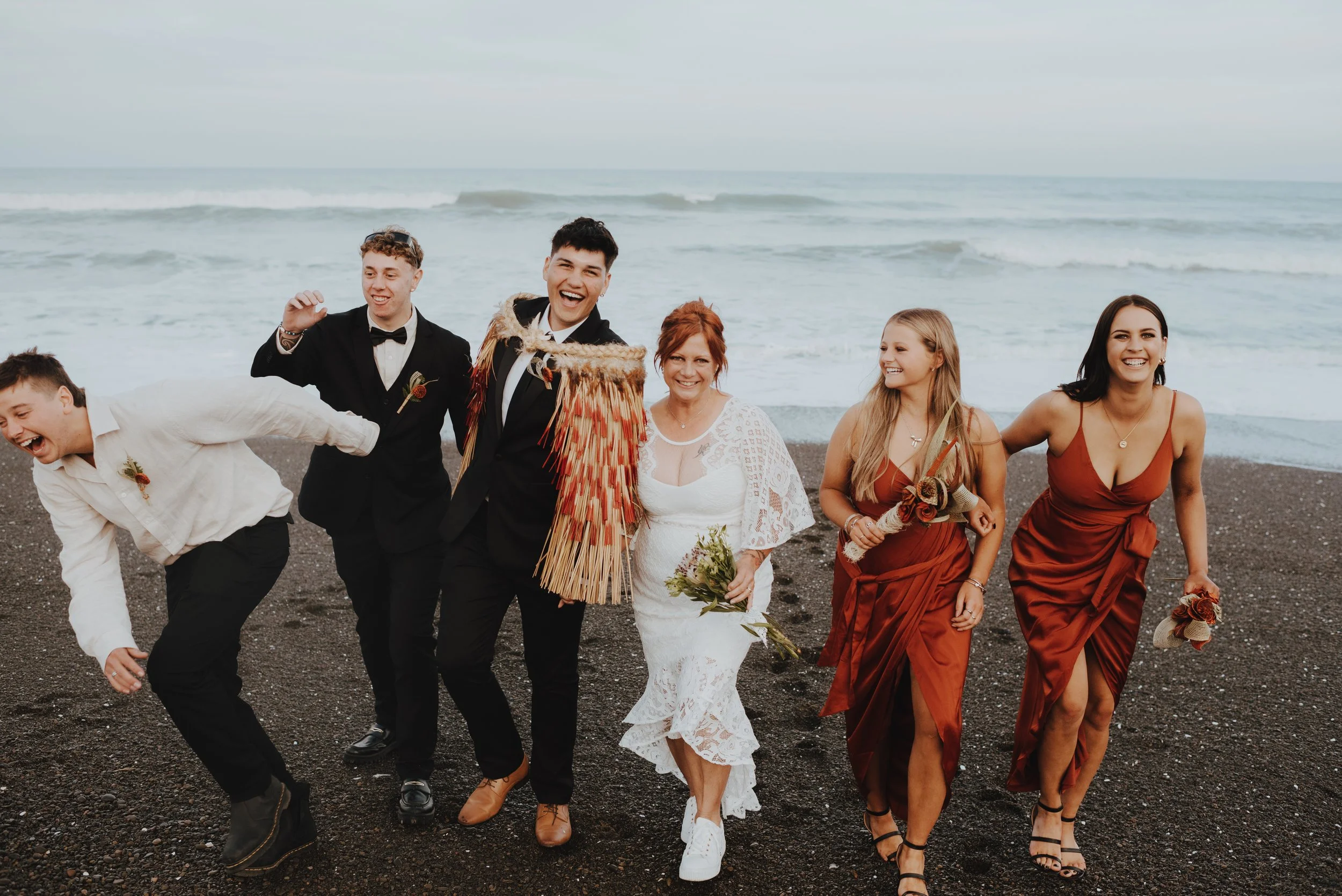 bridal party having fun for photos after the wedding