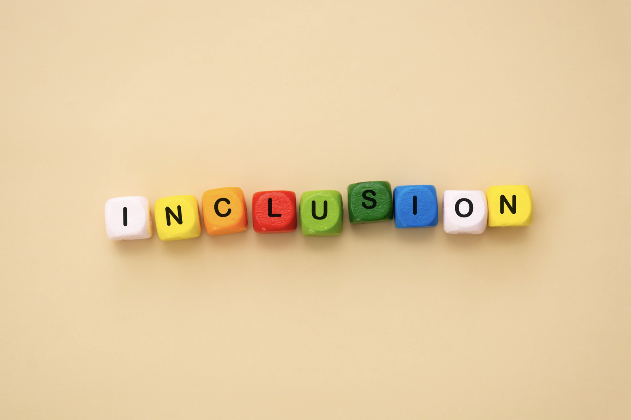 Colourful letter blocks spelling “INCLUSION” on a warm neutral background, representing SEND inclusion, reasonable adjustments and practical support that helps every pupil access learning.