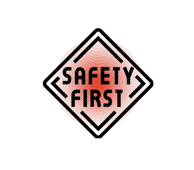 A safety sign with a red circular warning symbol and the words "SAFETY FIRST" inside a black diamond-shaped border.