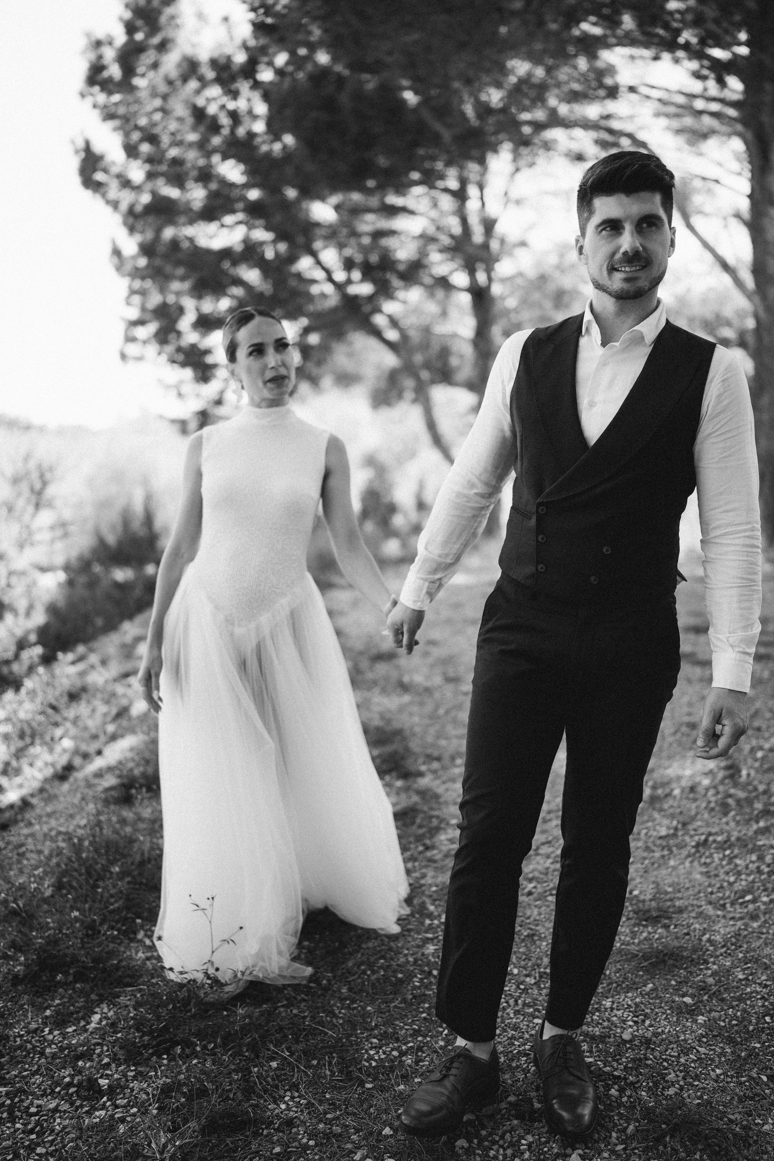 Ein schwarz-weiß Foto eines Brautpaares, das an einem Waldweg spazieren geht auf Mallorca – festgehalten vom Bart van Westrop, Hochzeitsfotograf in Mainz