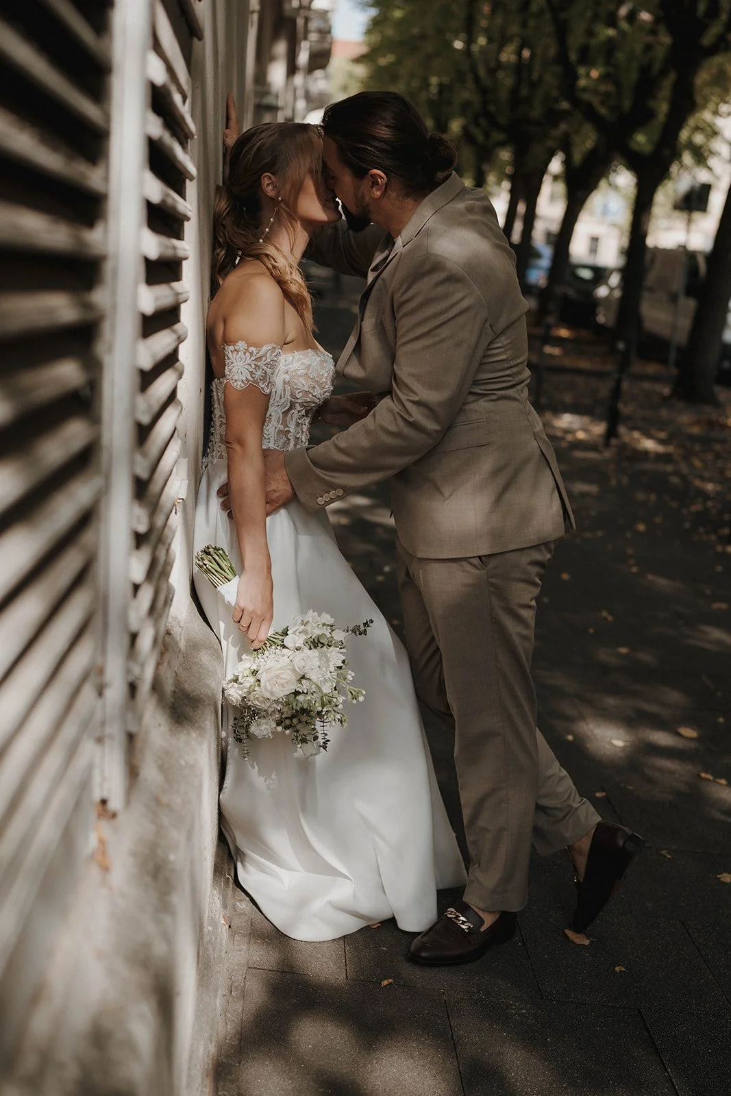 Ein Brautpaar steht eng beieinander an einer Wand, die Frau hält einen Brautstrauß – festgehalten vom Bart van Westrop, Hochzeitsfotograf in Mainz