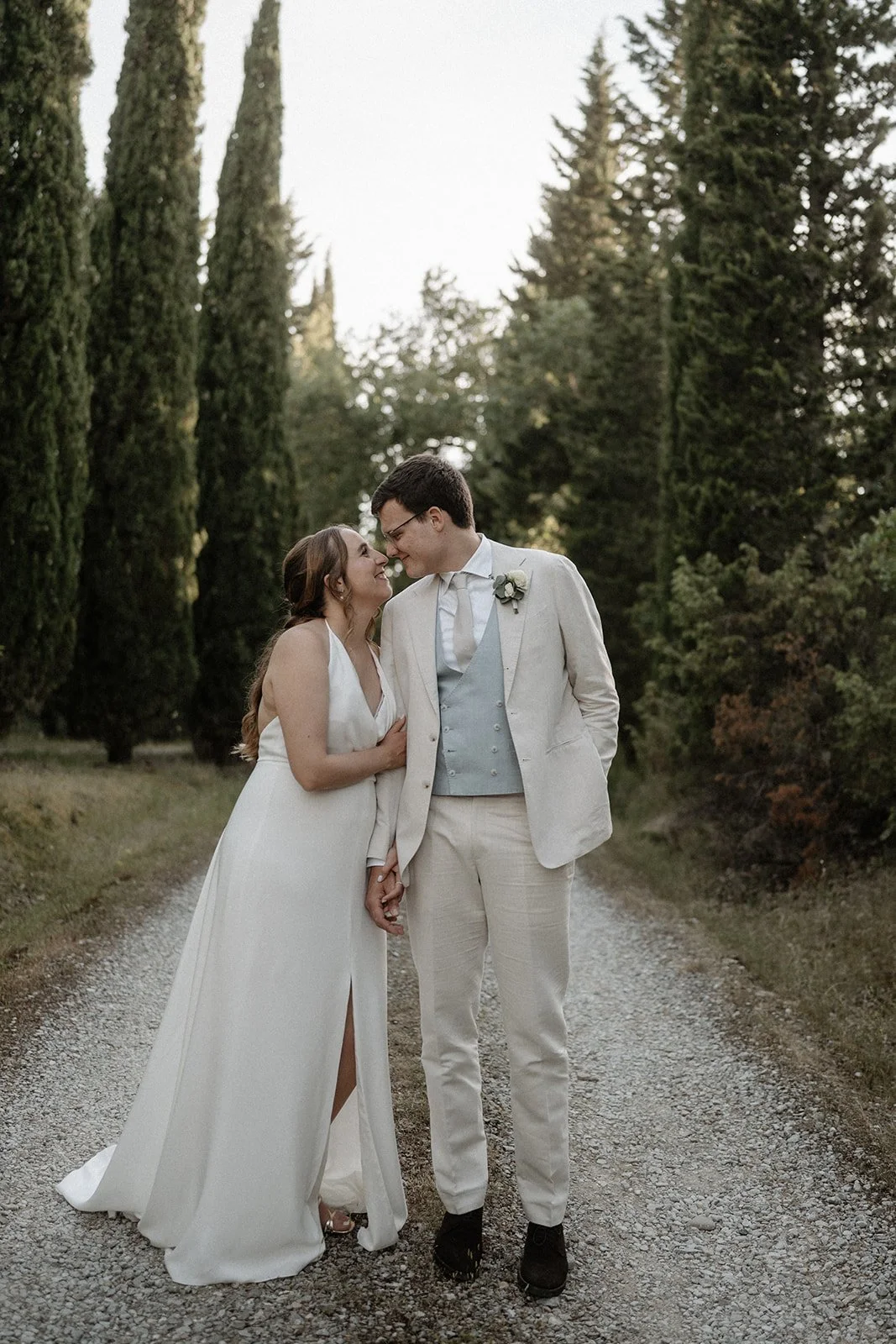 Brautpaar steht zwischen Zypressen während ihrer Hochzeit in der Toskana, festgehalten von Hochzeitsfotograf Mainz Bart van Westrop