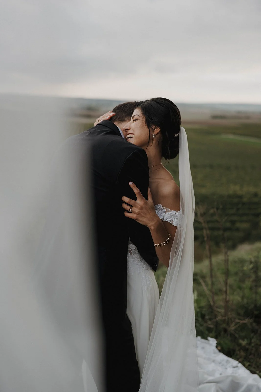 rautpaar steht im Rheingau zwischen Weinbergen mit Aussicht auf die Landschaft – festgehalten vom Bart van Westrop, Hochzeitsfotograf im Rheingau