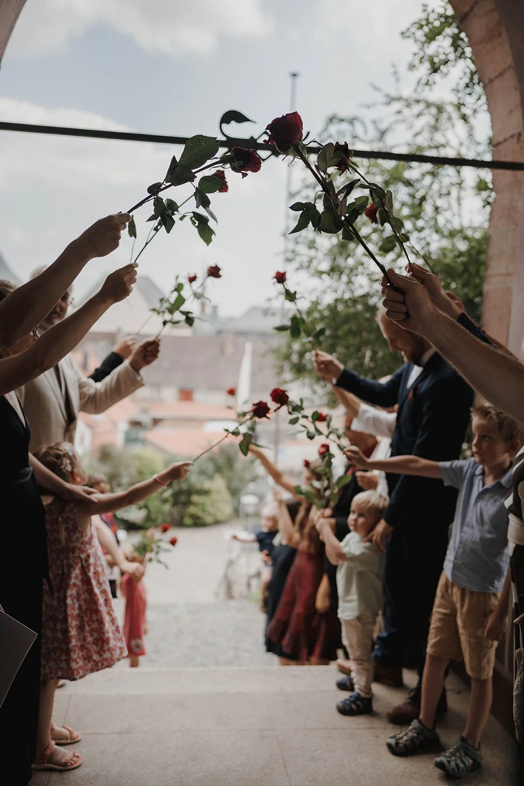 Menschen, Erwachsene und Kinder, die Blumensträuße aus roten Rosen auf einer Feier oder Zeremonie überreichen. Hochzeitsfotograf Standesamt Mainz