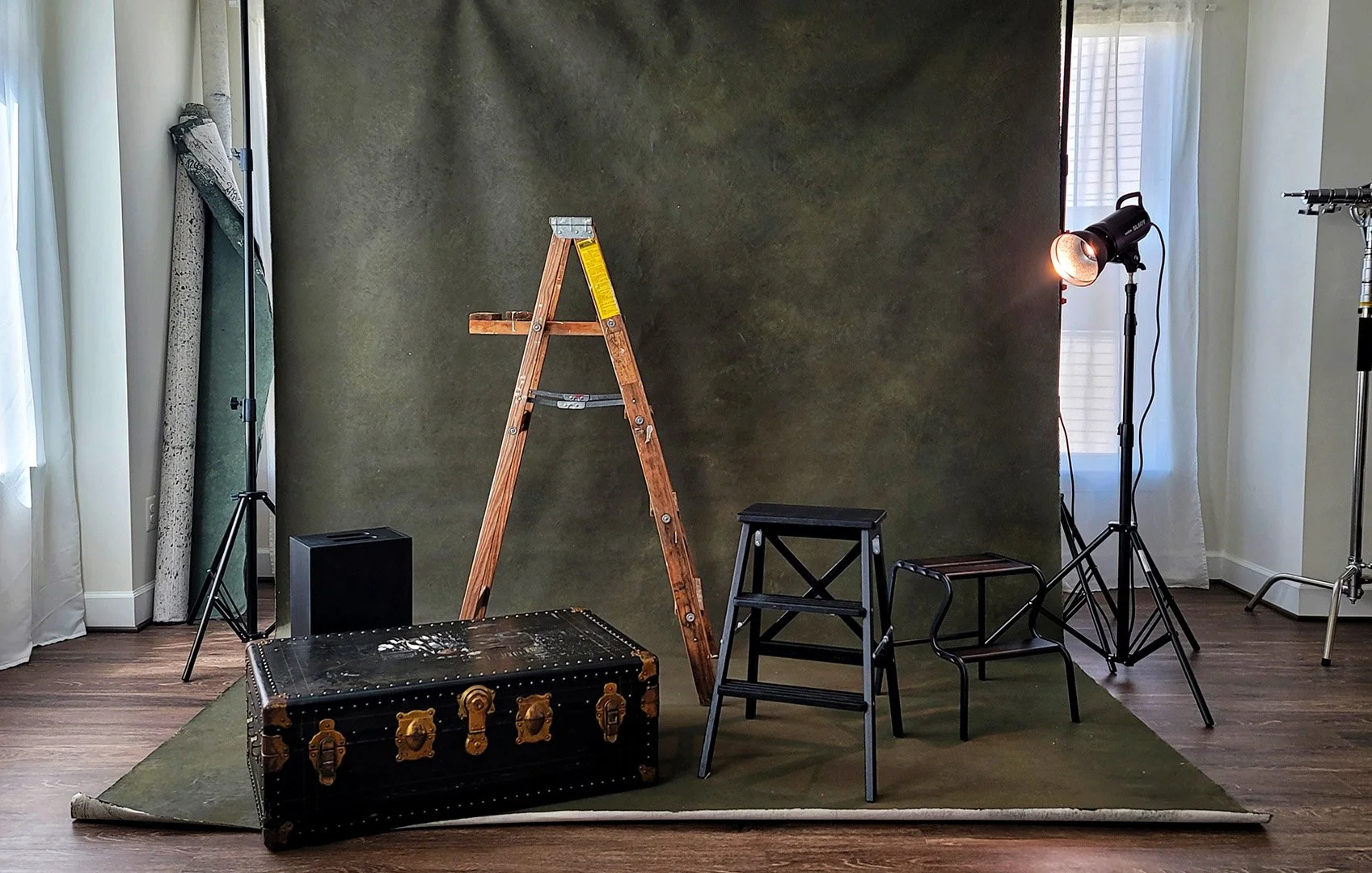 Hand Painted Canvas and props including a trunk, chair and two wooden step ladders, at a photo set in the private photograph studio of Northern Virginia based photographer, Myrtle Roy of MRoyPhoto.