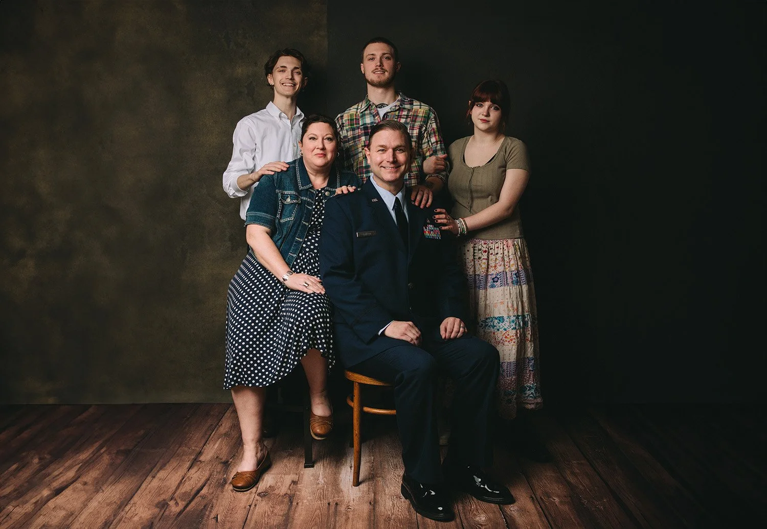 Military officer surrounded by his family posing and smiling while being photographed by Myrtle Roy in Easton MD>