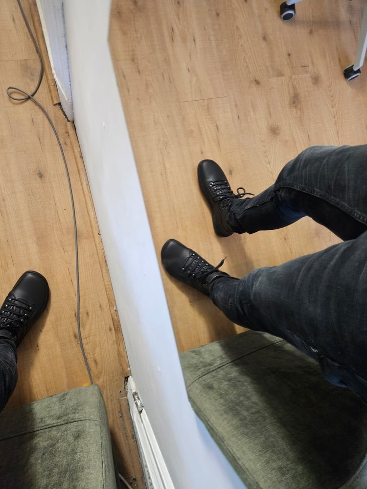 Skinners Explorer aan beide voeten, zittend gedragen onder een zwarte broek