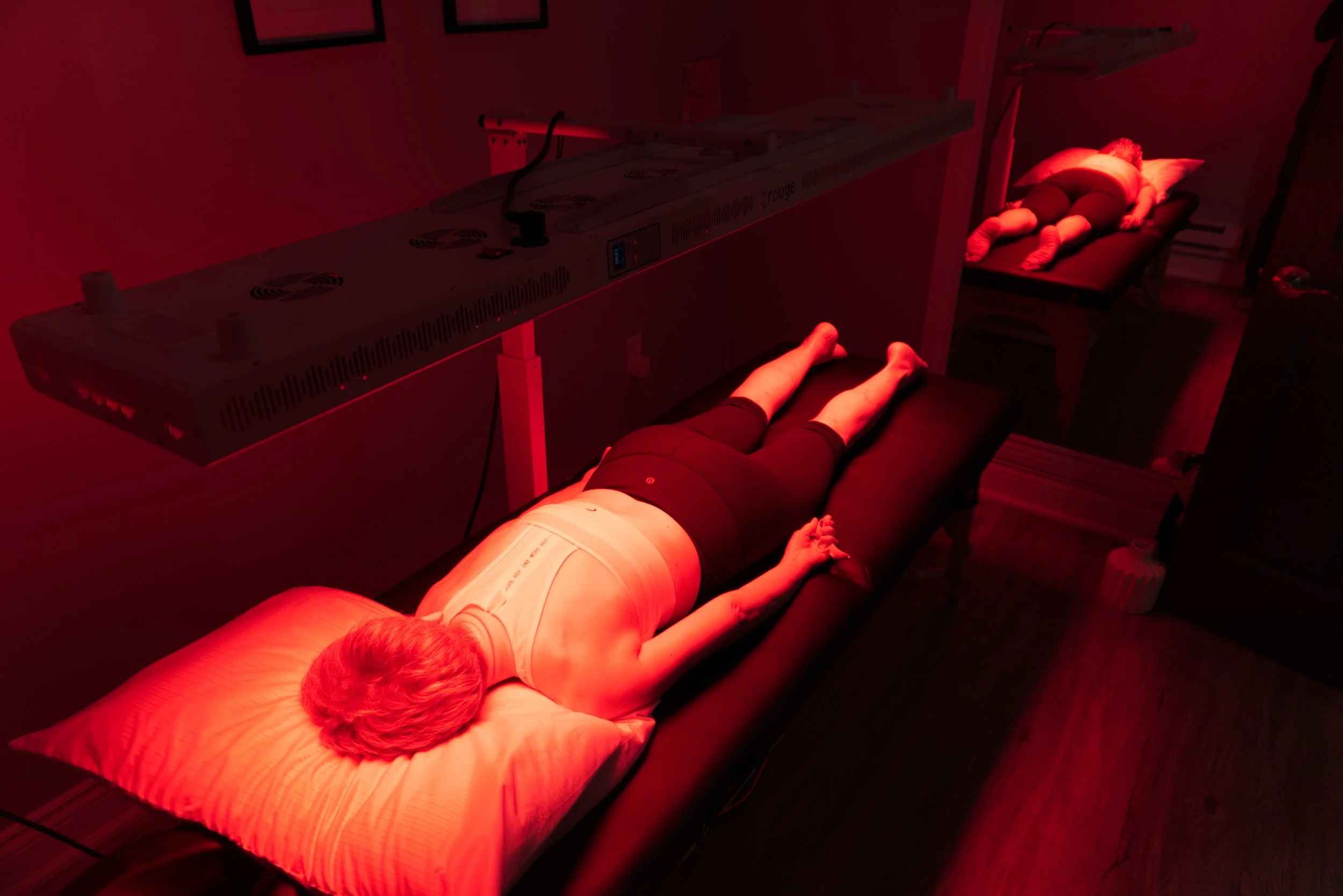 a client lying face receiving red light therapy