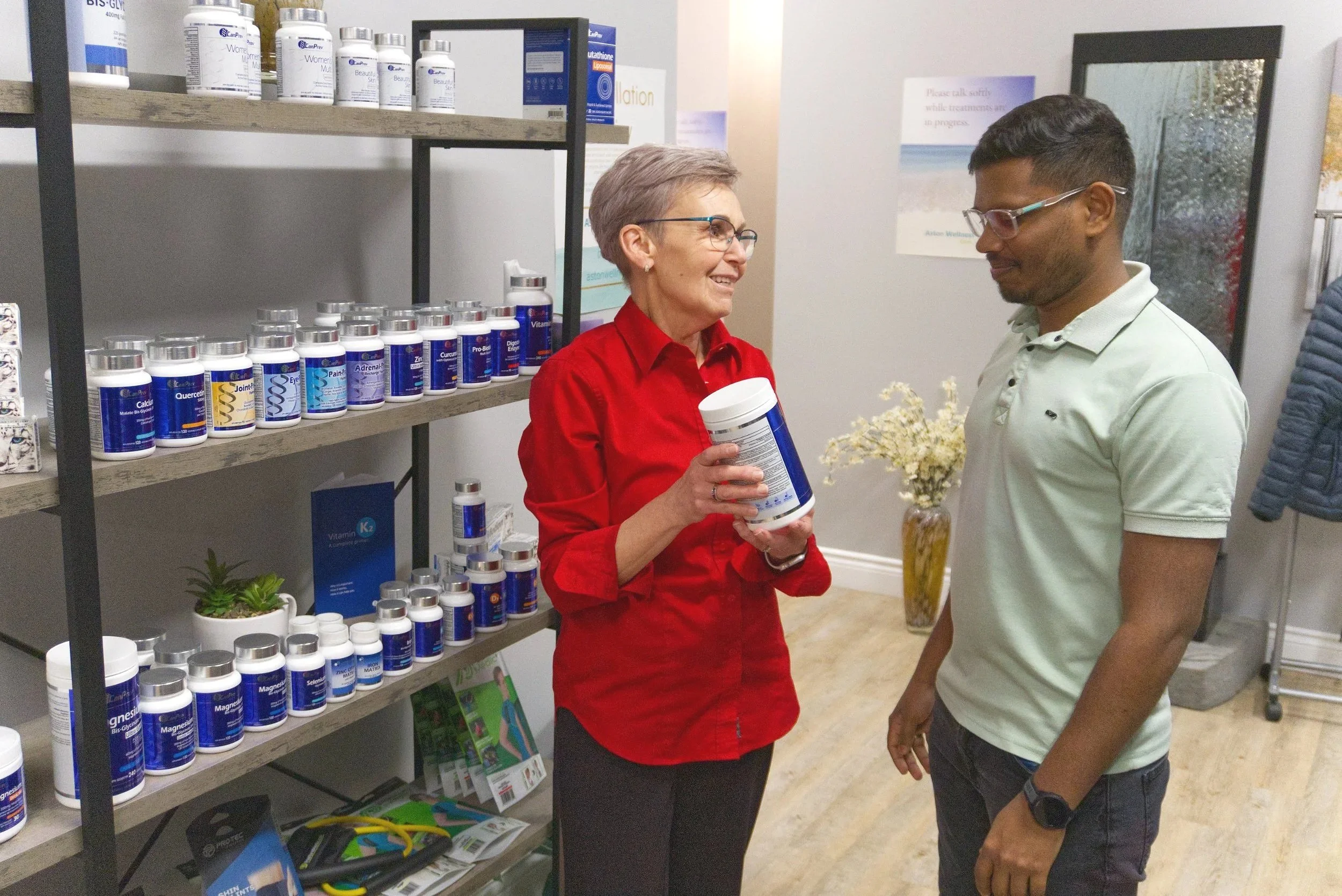 Aston team members, Deepesh and Marlene, discussing CanPrev products at Aston Wellness clinic.