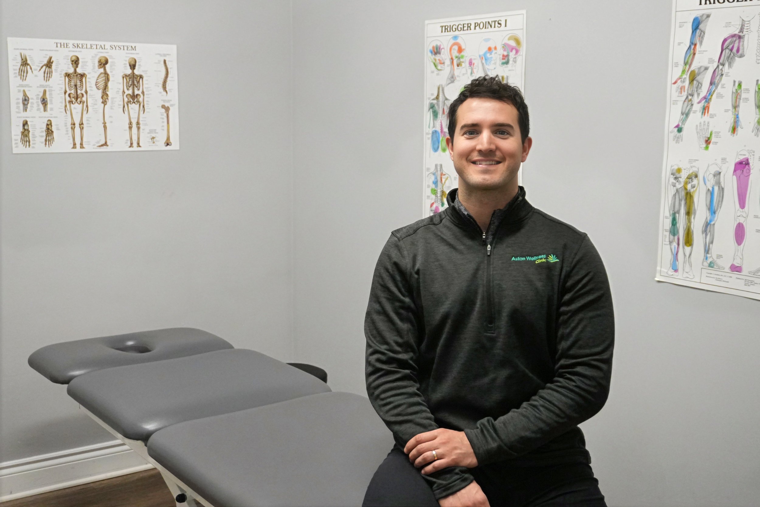 Dr. Manuel Gil sitting in his treatment room at Aston Wellness Clinic.