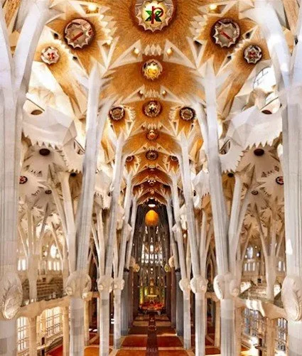 Interior view of Sagrada Familia church with ornate columns and colorful ceiling decorations