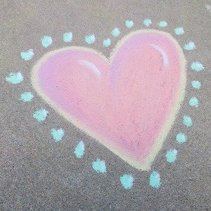 Chalk drawing of a pink heart with yellow border with blue dots around the outline