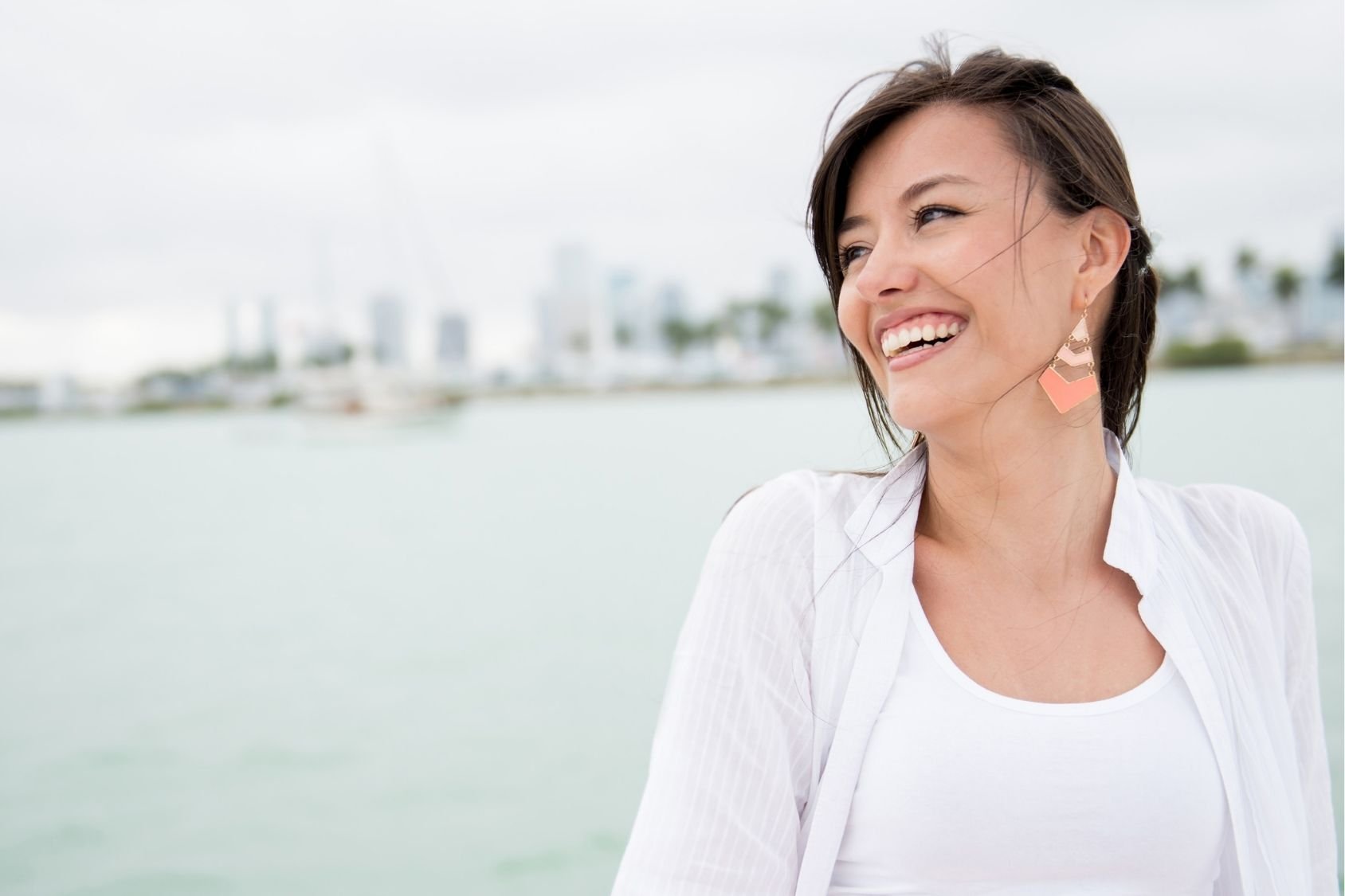 Young woman smiling by the water