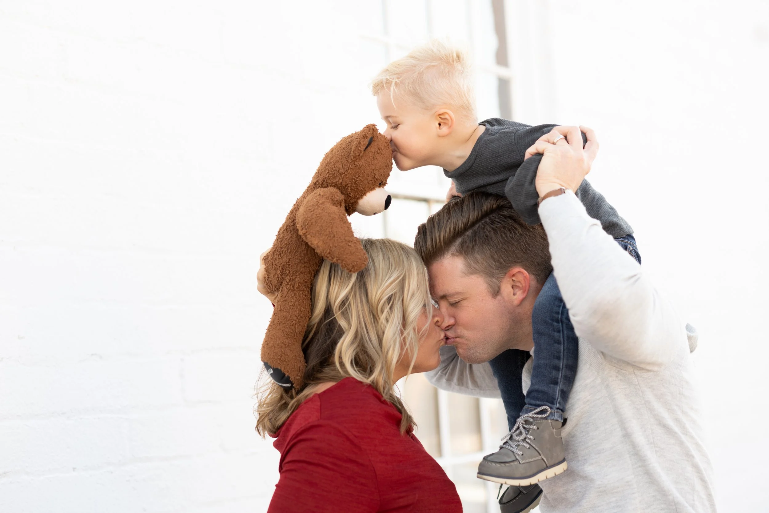 Family photographed in studio with dramatic light for a coordinated portrait.
