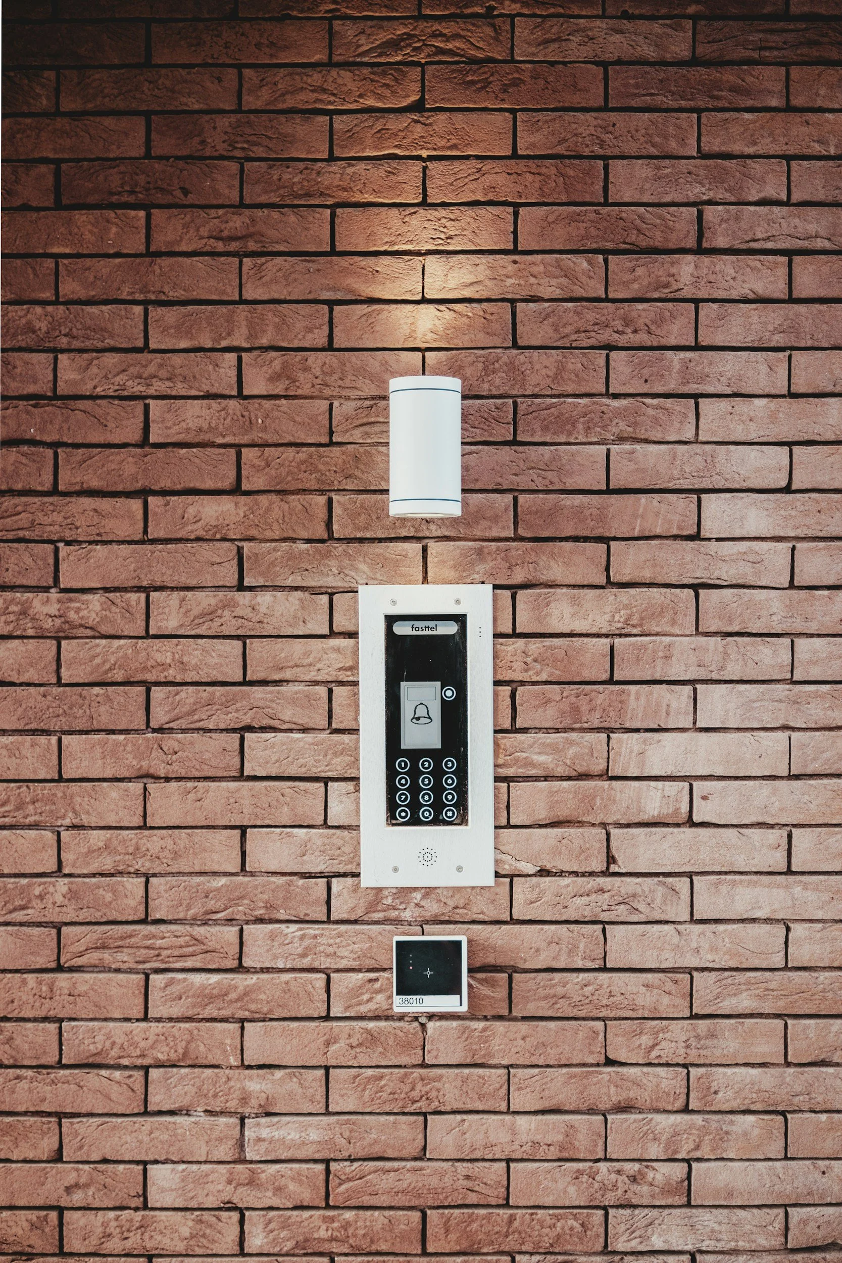Brick wall with intercom and light fixture