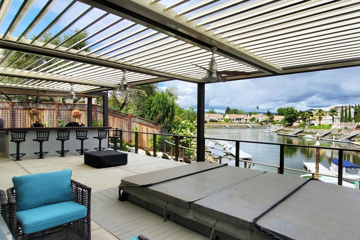 Waterfront deck featuring a Louvretec 180 Linear louvered roof system with adjustable blades, creating shade over an outdoor lounge and bar area overlooking the canal.
