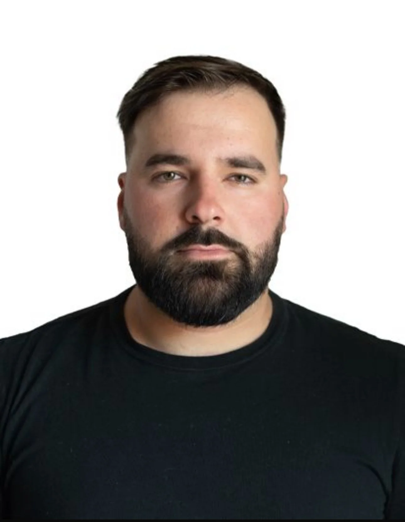 Man with beard in white shirt outdoors