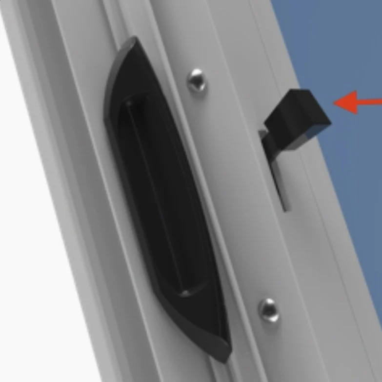 Close-up of a black handle and latch on a gray sliding door.