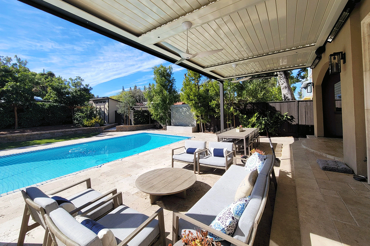 Outdoor poolside patio featuring a Louvretec 180 Linear louvered roof system, providing adjustable shade over a seating area with modern furniture.