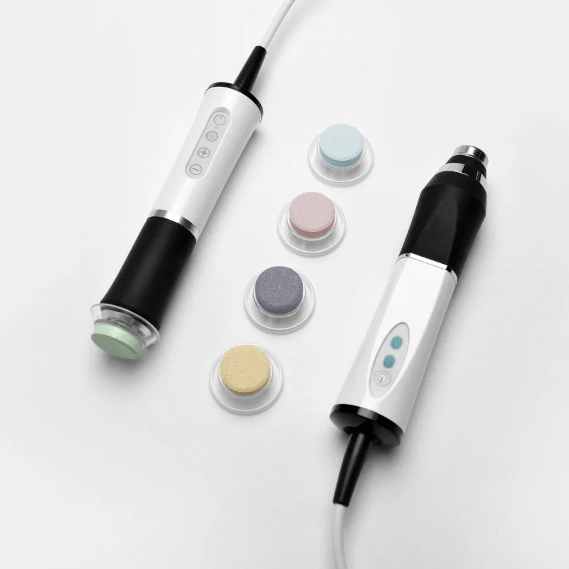 Handheld skincare devices by Oxygeneo with interchangeable color pads on a white background.