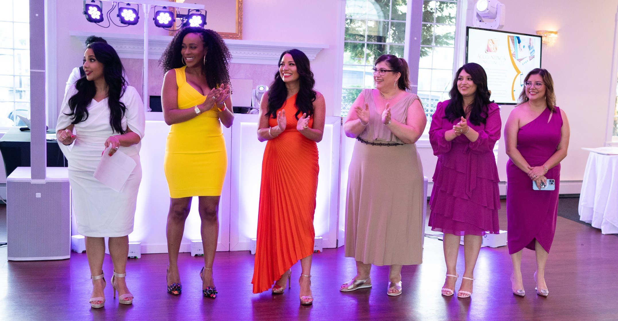 Group of women dressed in elegant attire standing on stage at the LABNNY Latina Business Network of New York gala event