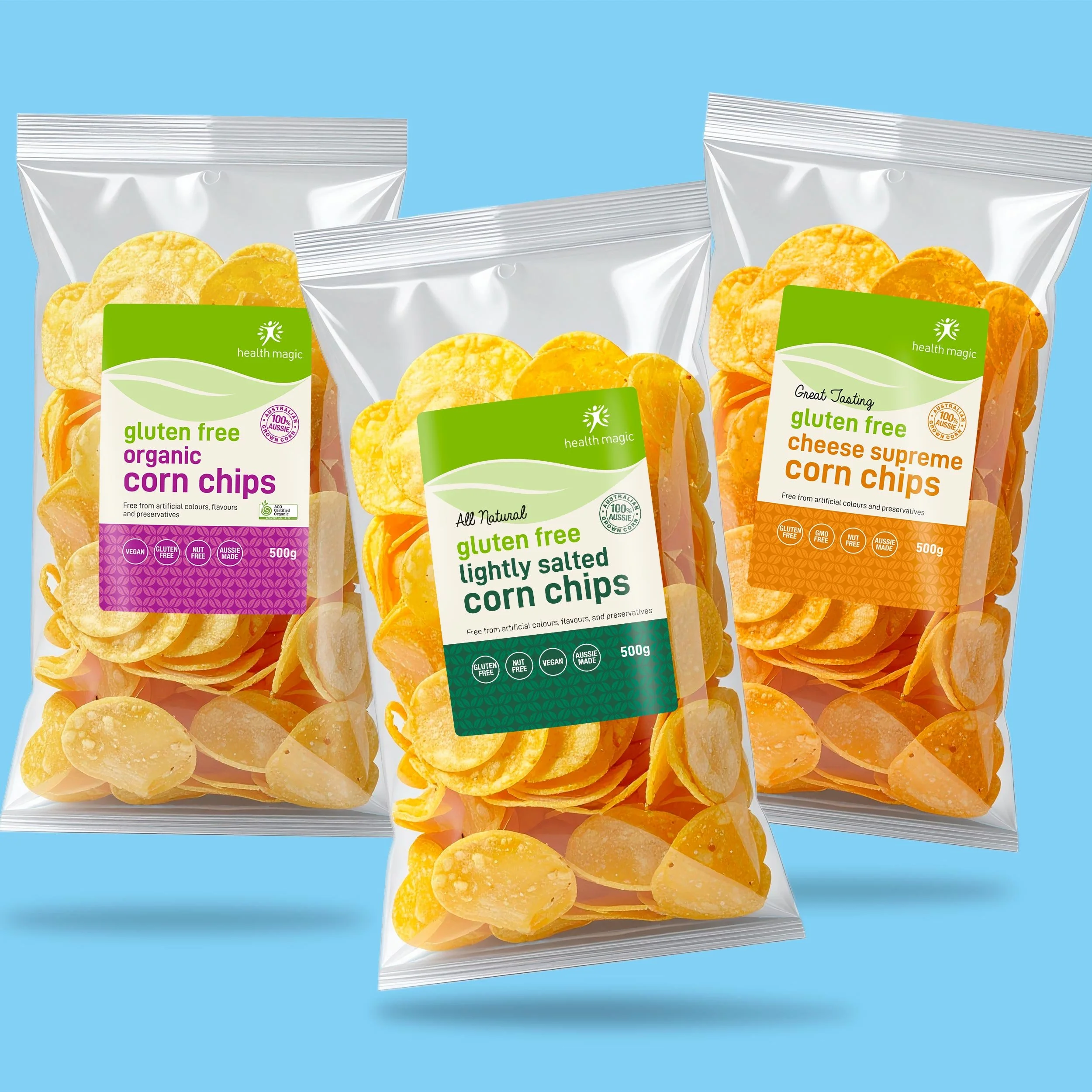 Three bags of corn chips on a blue background. The bags are labeled gluten free corn chips, including organic corn chips, lightly salted corn chips, and cheese supreme corn chips.