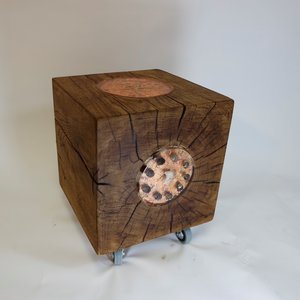 Un meuble en bois avec une partie en béton apparent et des roulettes en dessous.