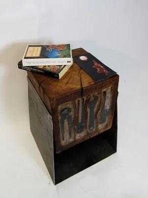 Une table en bois avec des livres et des brochures dessus. Le fond est blanc.