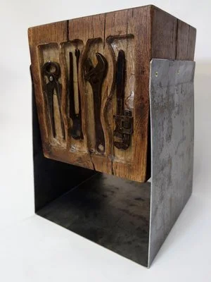 Une boîte en bois avec des outils suspendus à l'intérieur, entourée de structures en métal