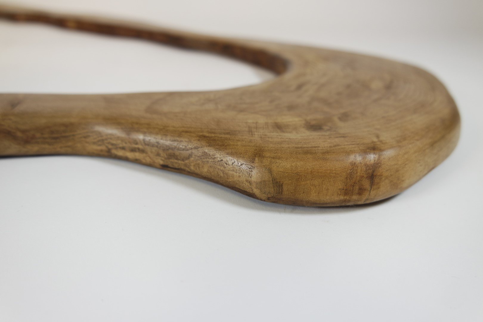 Une cuillère en bois posé sur une surface blanche