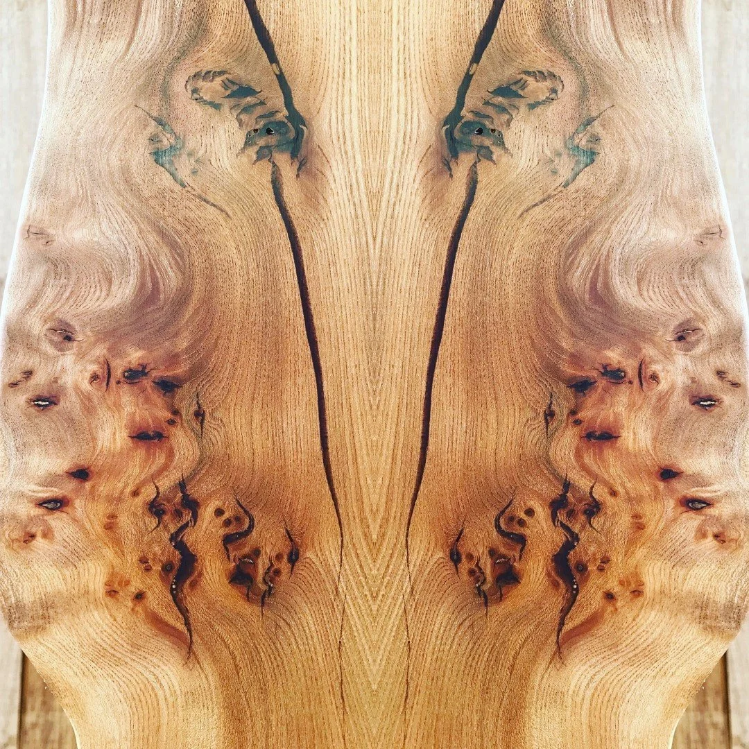 Surface en bois clair avec motifs naturels et taches sombres, symétrique au centre.