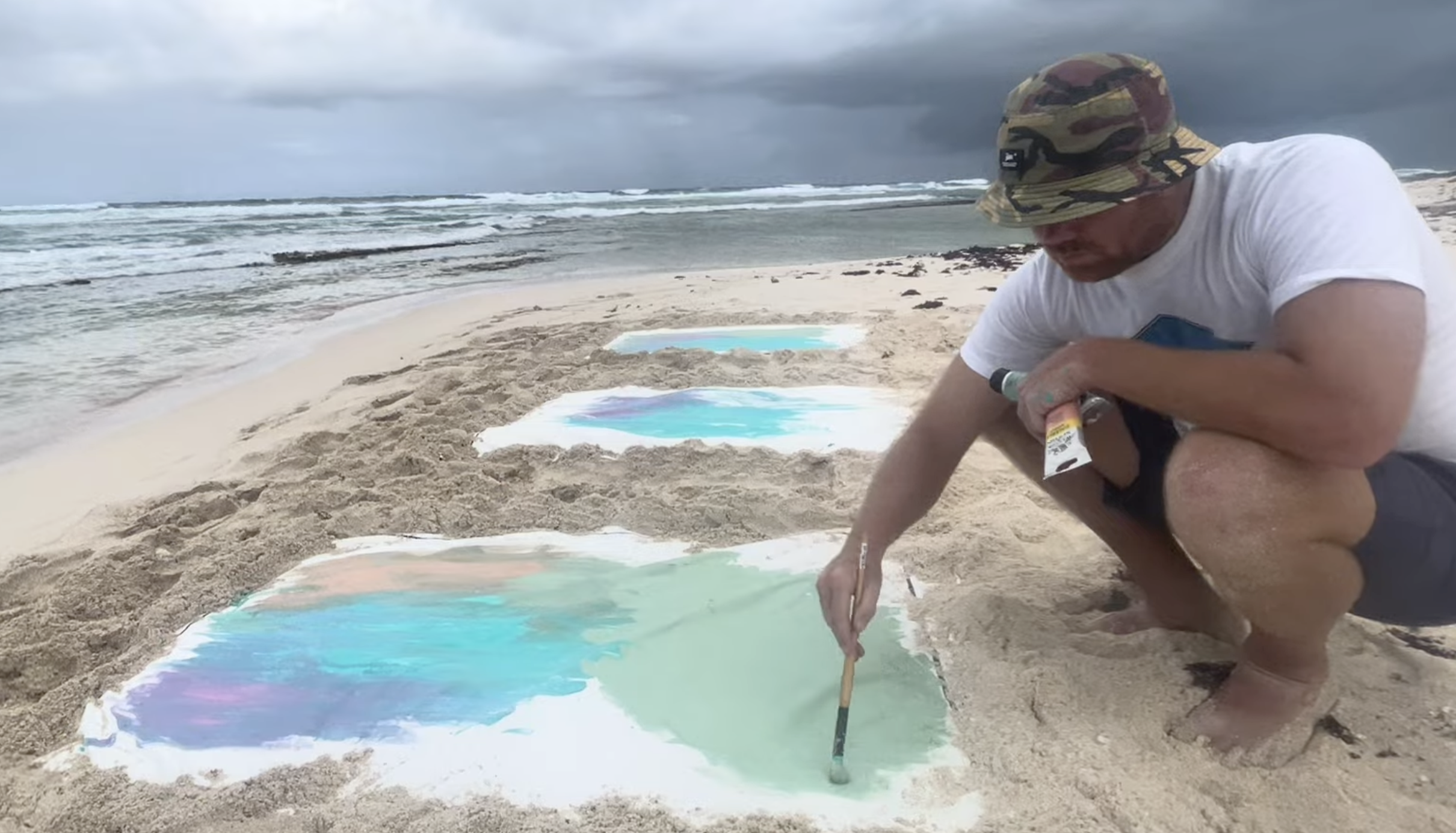 Roland painting outdoors at Boca Grandi in Aruba, surrounded by the island’s dramatic coastal landscape and Caribbean scenery.