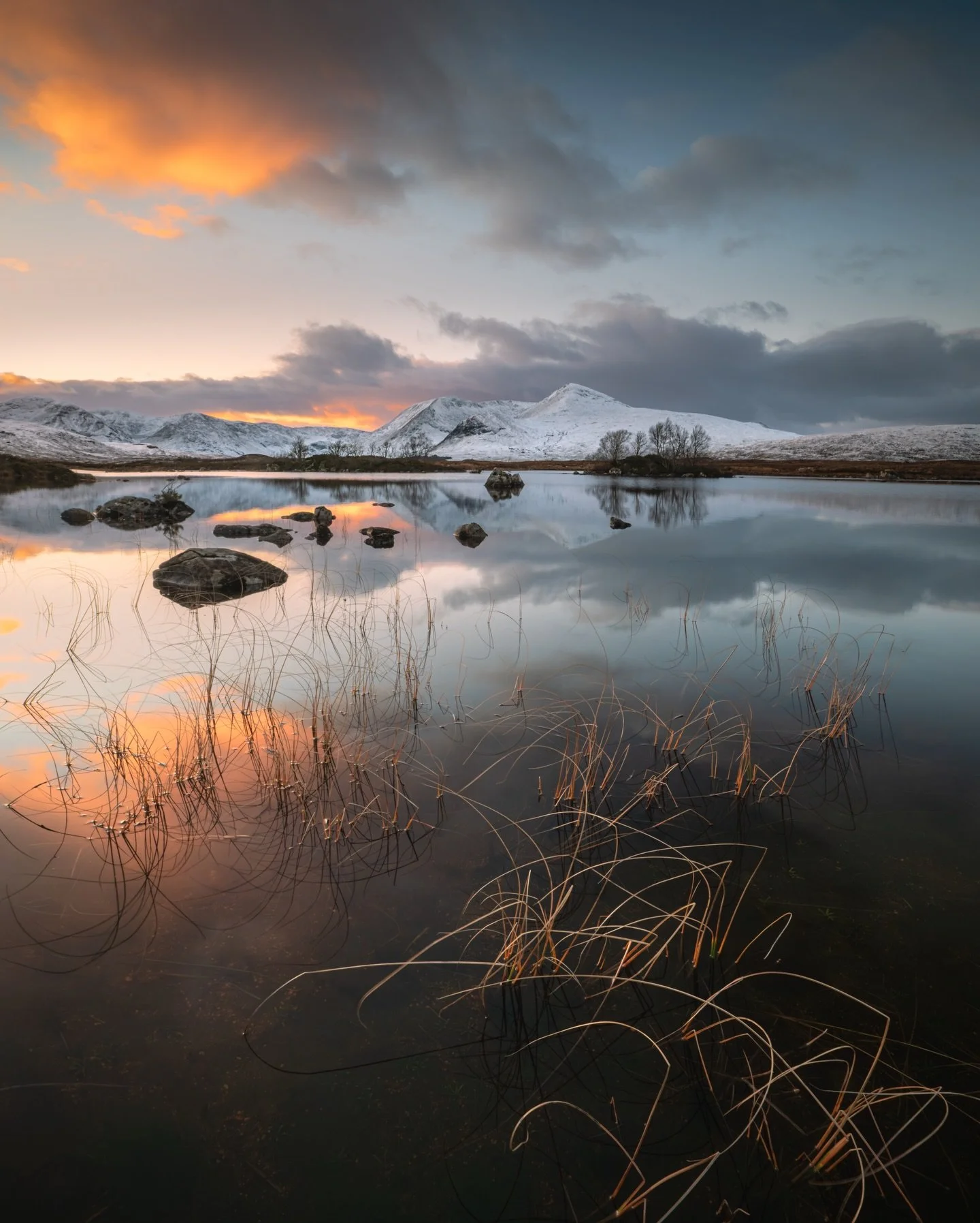 Winter sunset at Lochan na h-Achlaise, Scotland
 An amazing stillness - the loch completely calm with soft winter colours slowly fading into reflection. 

#Glencoe #WinterScotland #SunsetColours #Stillness #Reflections #LandscapePhotography #ChasingL