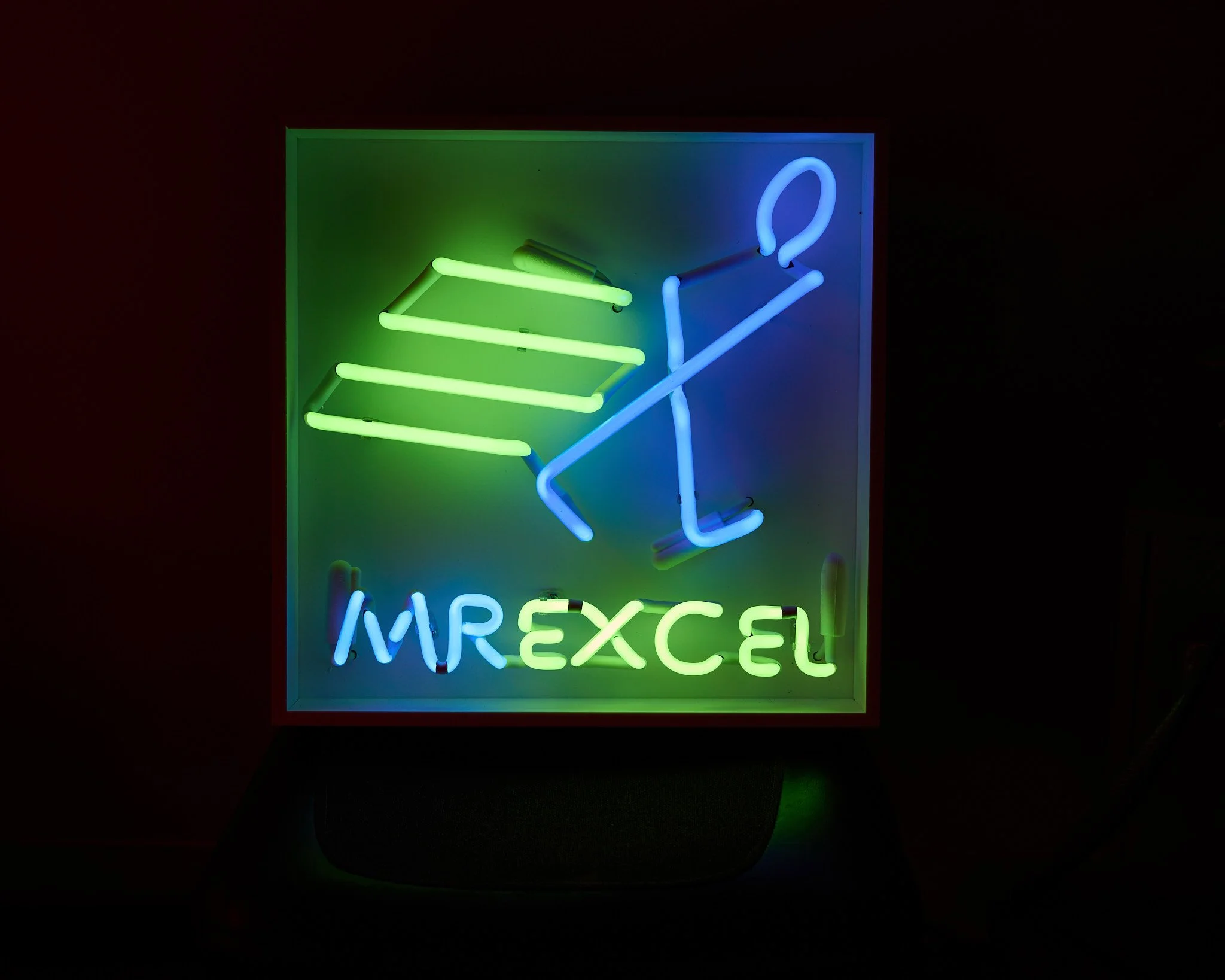 Popular internet personality Mr. Excel came to us looking for a neon light version of his logo. Made with royal blue and green neon, in a white-on-white shadow box, this piece measures 18" square and includes a dimmer to set the intensity when using