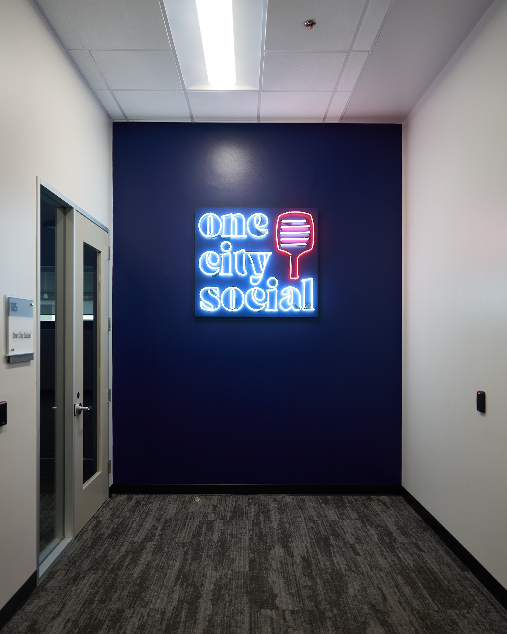 We painted our standard PVC background material to match the accent wall at One City Social, and hung the sign from a french cleat just above a recessed power outlet. The outcome, a sign that floats right on the surface of the wall, almost like magi
