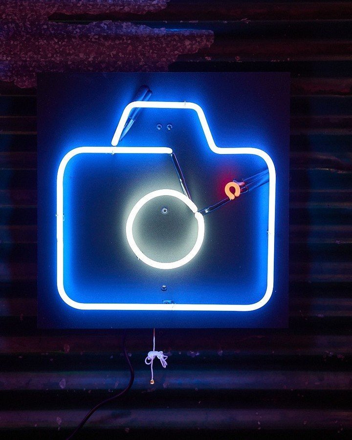 A neon camera created during a workshop
