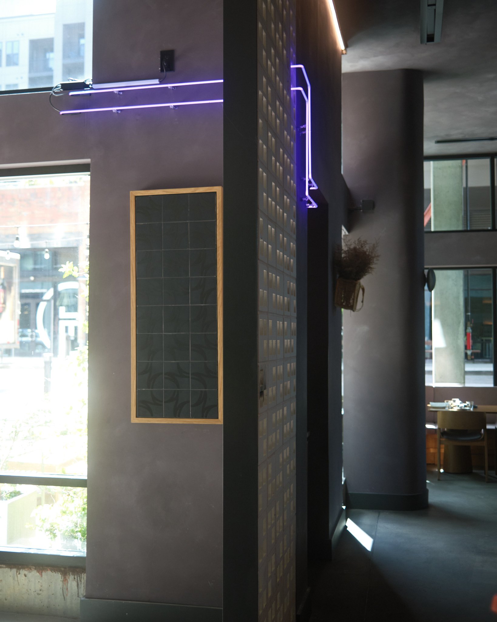 As you turn the corner into the dining room, the neon follows you through the wall, emerging from the back side of the blocks.