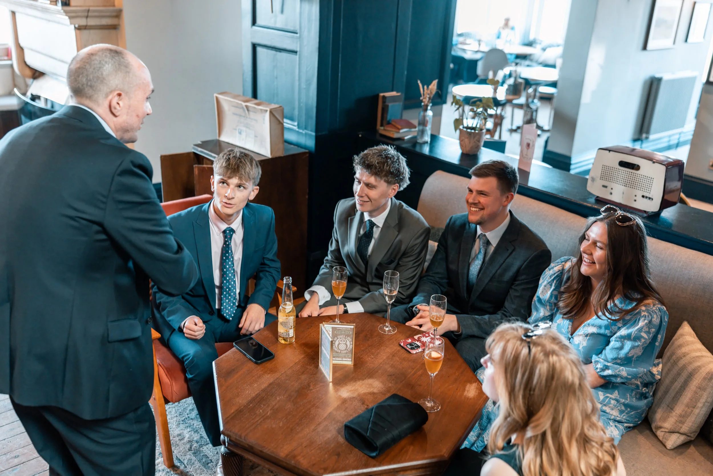 David Richards is performing for a group of five young adults -  four men and one woman - at a wedding reception.
