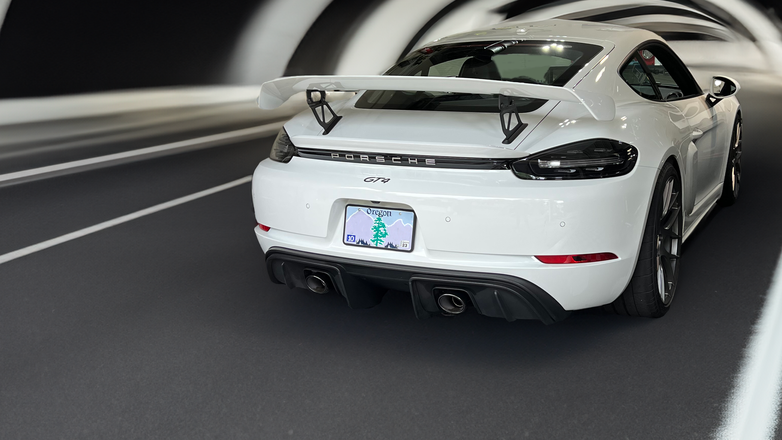 White Porsche 718 GT4 with 718 Cayman GT4 Extra AOA Wing Tall Riser Brackets