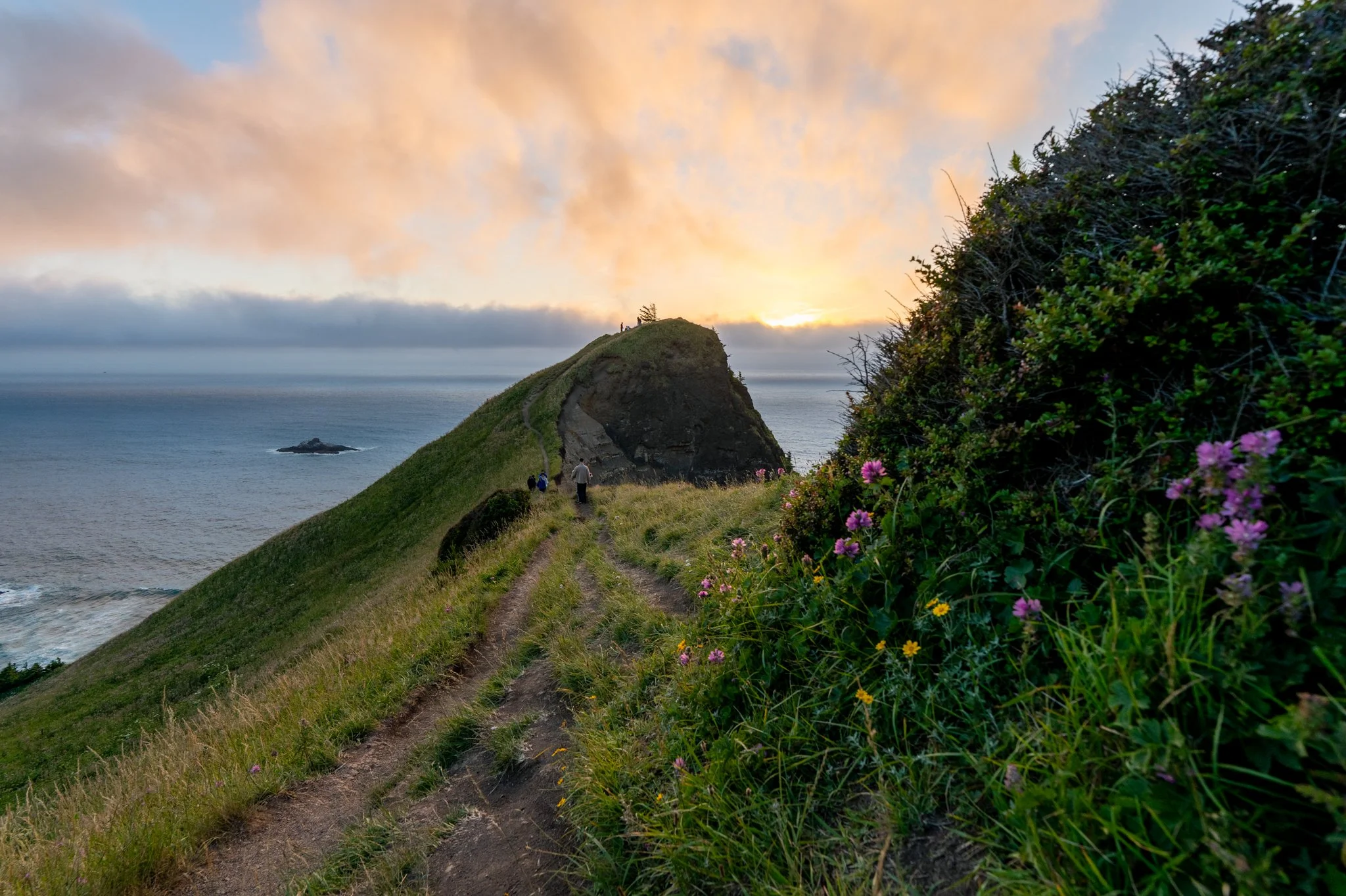 A couple hiking to the top of God's Thumb after proposing at the knoll in lincoln city oregon
